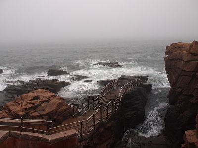 [Walkway, with railings all around, leading to a rock jutting into the ocean.]